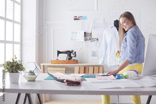 Fashion young designer woman measuring a dress. © lenets_tan