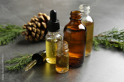 Composition with bottles of conifer essential oil on grey table