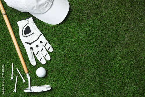 Flat lay composition with golf equipment on artificial grass, space for text photo