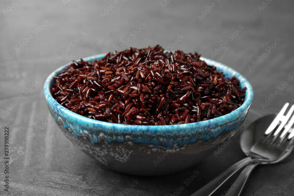 Bowl with delicious cooked brown rice on grey table Bowl with delicious cooked brown rice on grey table