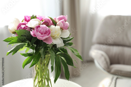 Fototapeta Naklejka Na Ścianę i Meble -  Vase with bouquet of beautiful peonies in room, space for text
