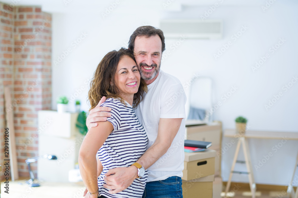 Middle age senior couple moving to a new house, smiling happy in love with apartmant
