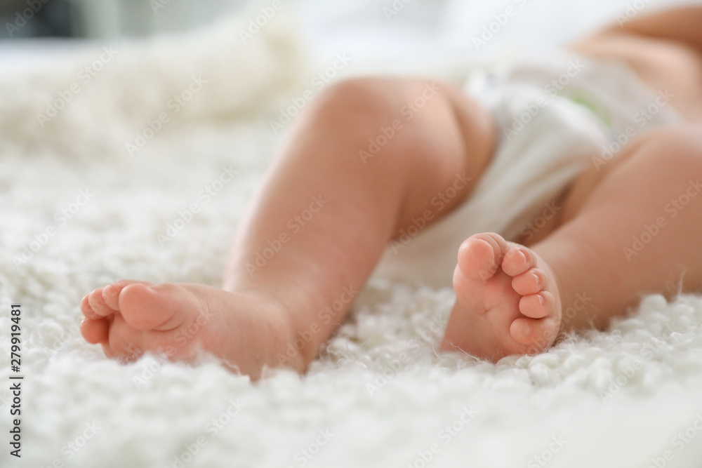 Cute little baby lying on bed, closeup of legs Cute little baby lying on bed, closeup of legs
