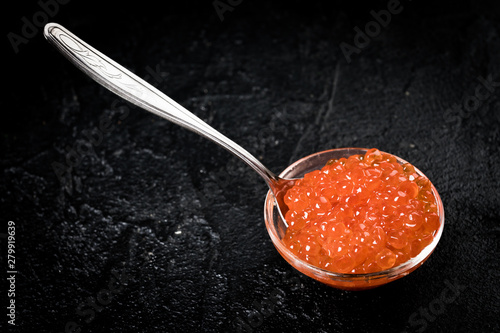 Red Caviar in bowl over black background