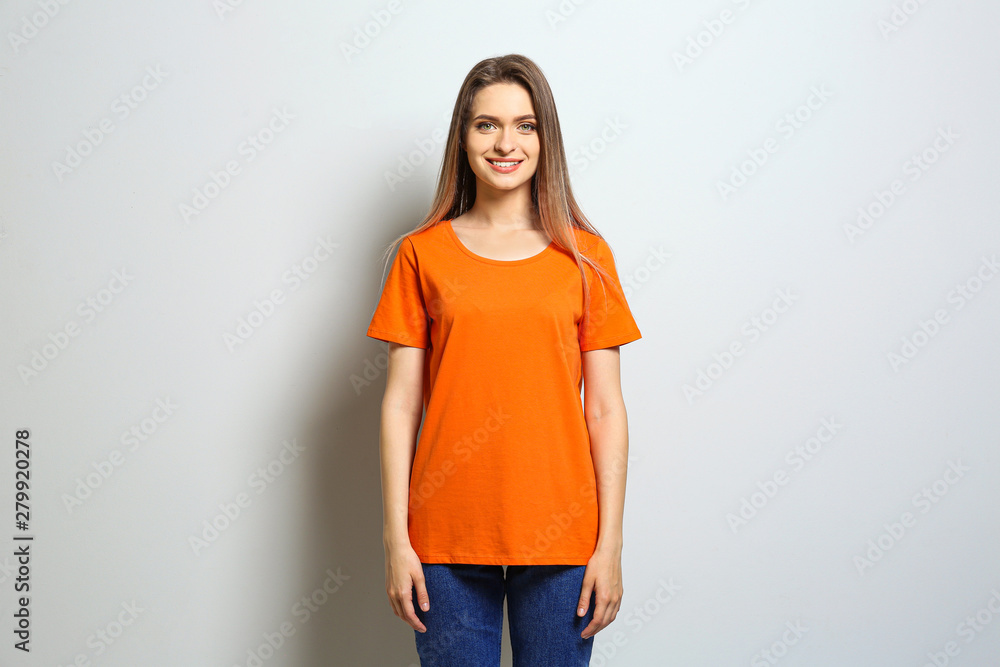 Young woman wearing blank t-shirt on light background. Mockup for design Young woman wearing blank t-shirt on light background. Mockup for design