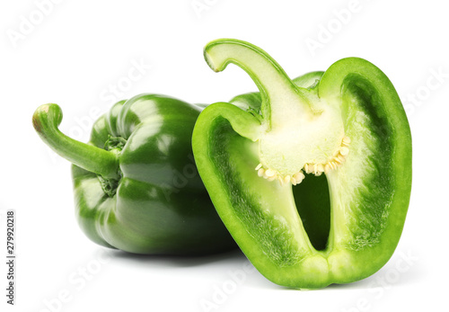 Cut and whole tasty green bell peppers on white background