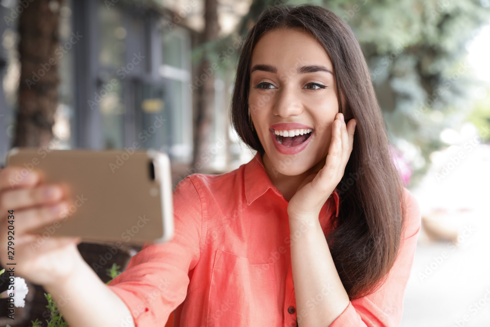 Beautiful young woman taking selfie outdoors on sunny day Beautiful young woman taking selfie outdoors on sunny day