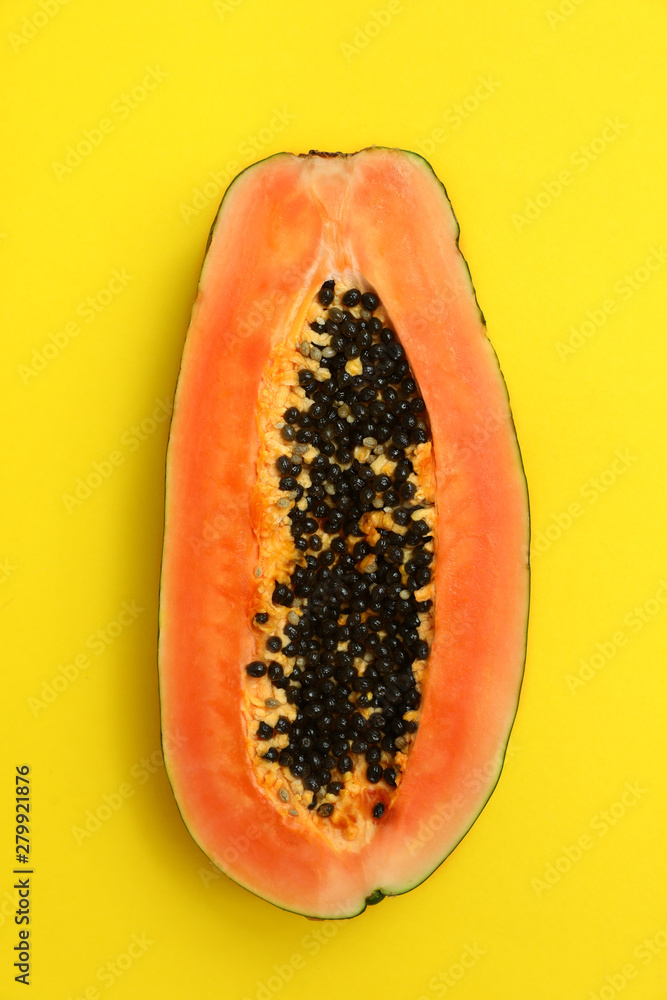 Fresh juicy halved papaya on yellow background, top view Fresh juicy halved papaya on yellow background, top view