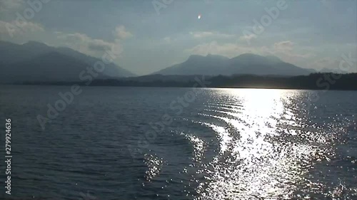Sun Sparkles on an Alpine Lake in a Ferry's Wake