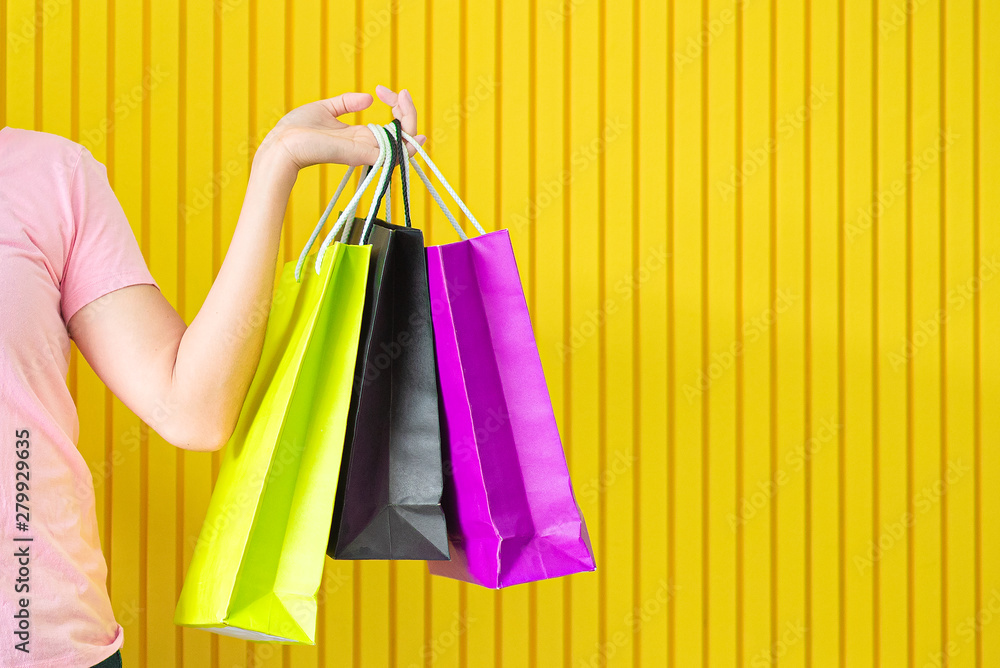 Asian women hold a shopping bag in a colorful yellow background,summer sale concept