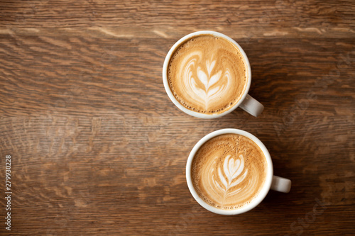 Two cups of coffee on a dark wooden background