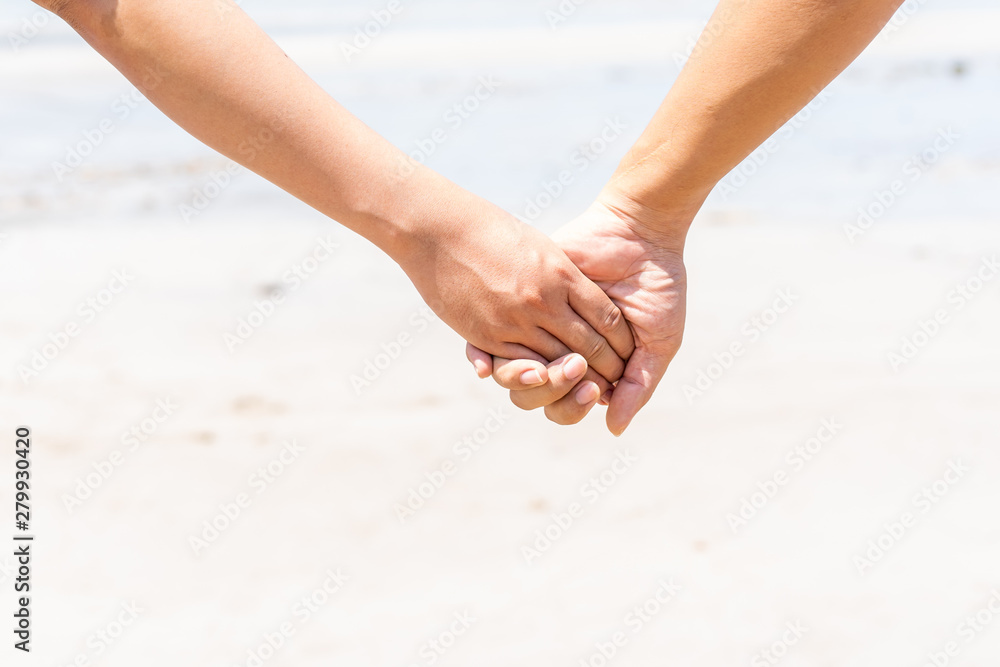 Couple holding their hands together at the beach.  Processed in vintage color tone.