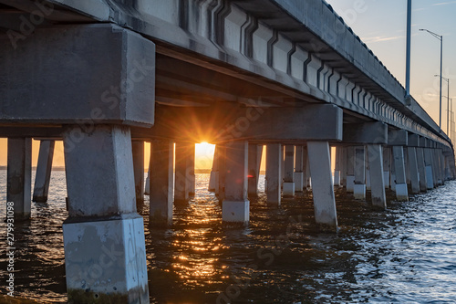 Sunrise under a bridge over the water