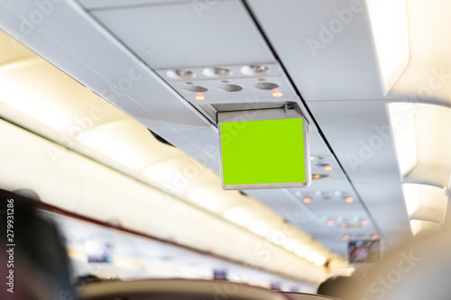 Over head in-flight entertainment screen with empty green screen close up.  On board entertainment screen with green screen background.