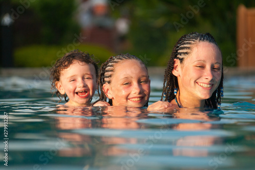 Three children playing piggyback while swimming in a pool in Cruz Bay  St. John  USVI