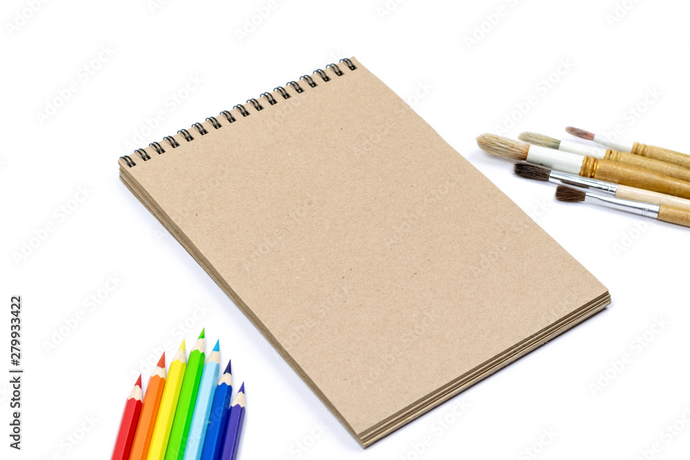 Notebook, Coloured pencils, Watercolour brushes isolated on white background for mockup. Flat lay, top view. Back to school concept. Notebook, Coloured pencils, Watercolour brushes isolated on white background for mockup. Flat lay, top view. Back to school concept.