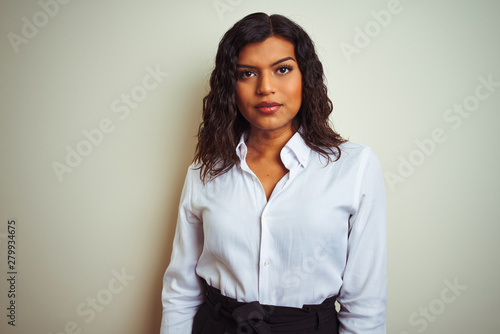 Beautiful transsexual transgender elegant businesswoman over isolated white background with serious expression on face. Simple and natural looking at the camera.
