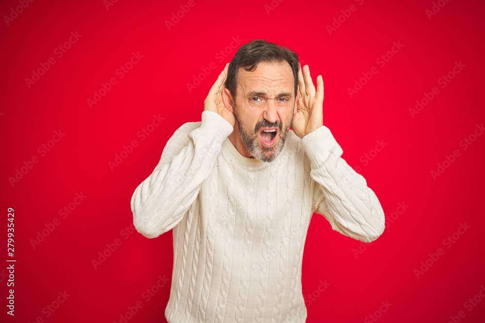 Handsome middle age senior man with grey hair over isolated red background Trying to hear both hands on ear gesture, curious for gossip. Hearing problem, deaf Handsome middle age senior man with grey hair over isolated red background Trying to hear both hands on ear gesture, curious for gossip. Hearing problem, deaf