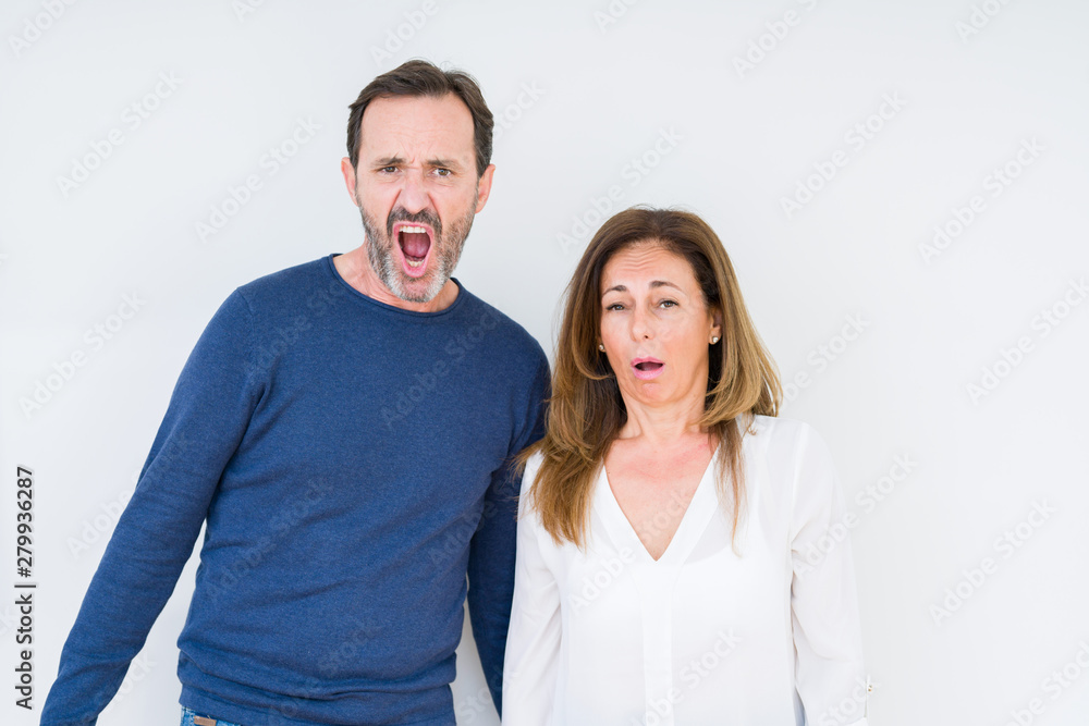 Beautiful middle age couple in love over isolated background In shock face, looking skeptical and sarcastic, surprised with open mouth Beautiful middle age couple in love over isolated background In shock face, looking skeptical and sarcastic, surprised with open mouth