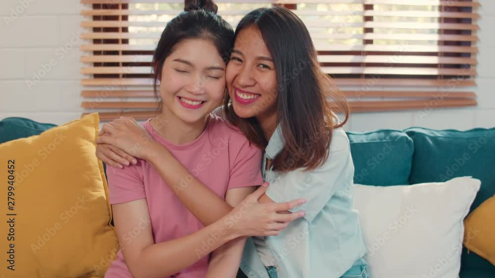 Portrait Young Asia Lesbian lgbtq women couple feeling happy smiling at home. Asian lover female relax toothy smile looking to camera while lying sofa in living room in morning concept. Slow motion. Portrait Young Asia Lesbian lgbtq women couple feeling happy smiling at home. Asian lover female relax toothy smile looking to camera while lying sofa in living room in morning concept. Slow motion.