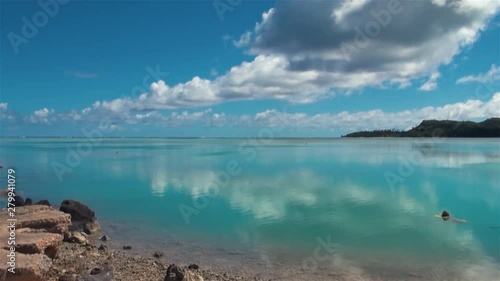 Aitutaki Lagoon Reef Sea View Seascape of Rocky Shore & Coral Reef Beach & Blue Seawater In Cook Islands Polynesia South Pacific.Shot From Arutanga Harbour Port Marina.Wide Angle & Blue Background photo