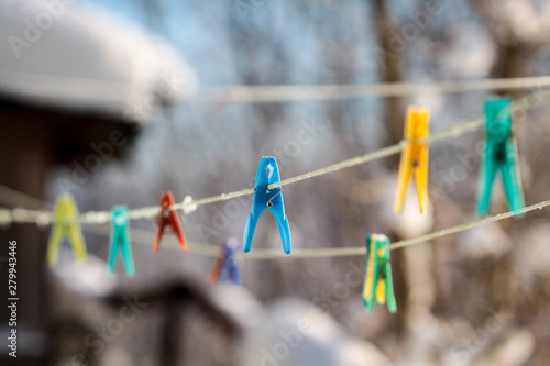 Colorful clothespins on a rope in the yard.