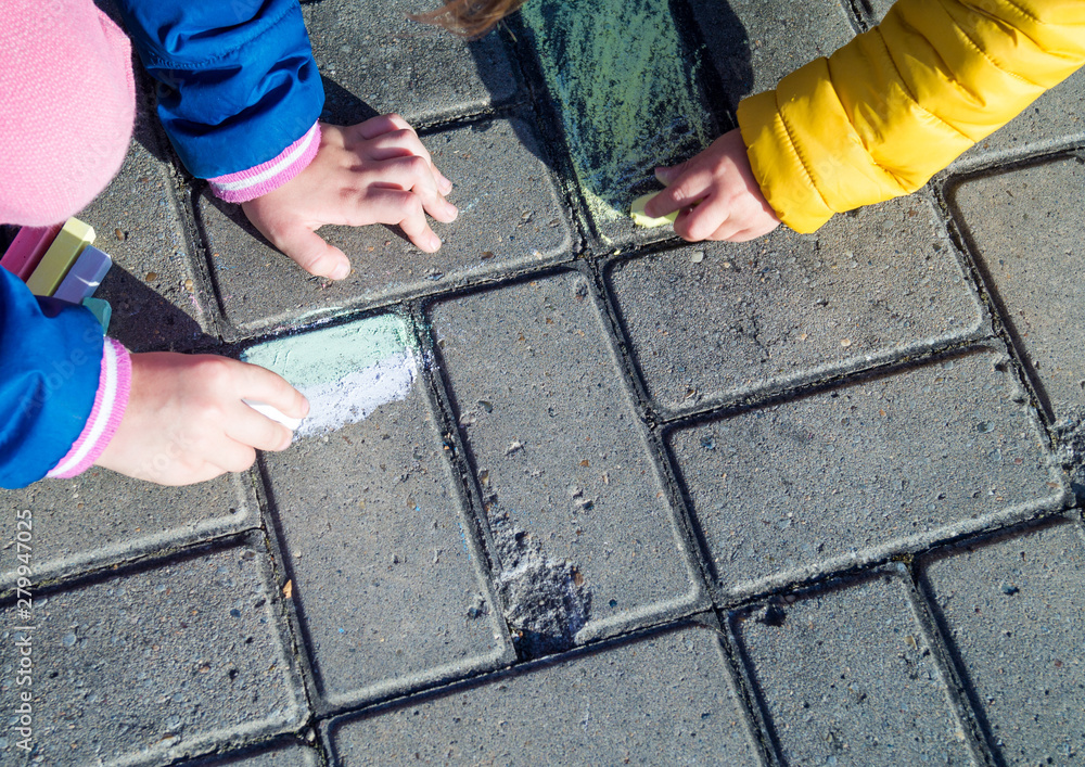Children draw in chalk on the asphalt on the street. Life style. Children draw in chalk on the asphalt on the street. Life style.