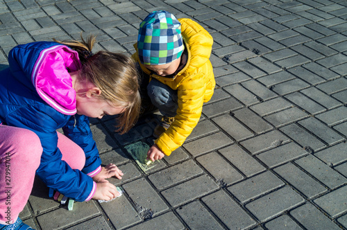 Children draw in chalk on the asphalt on the street