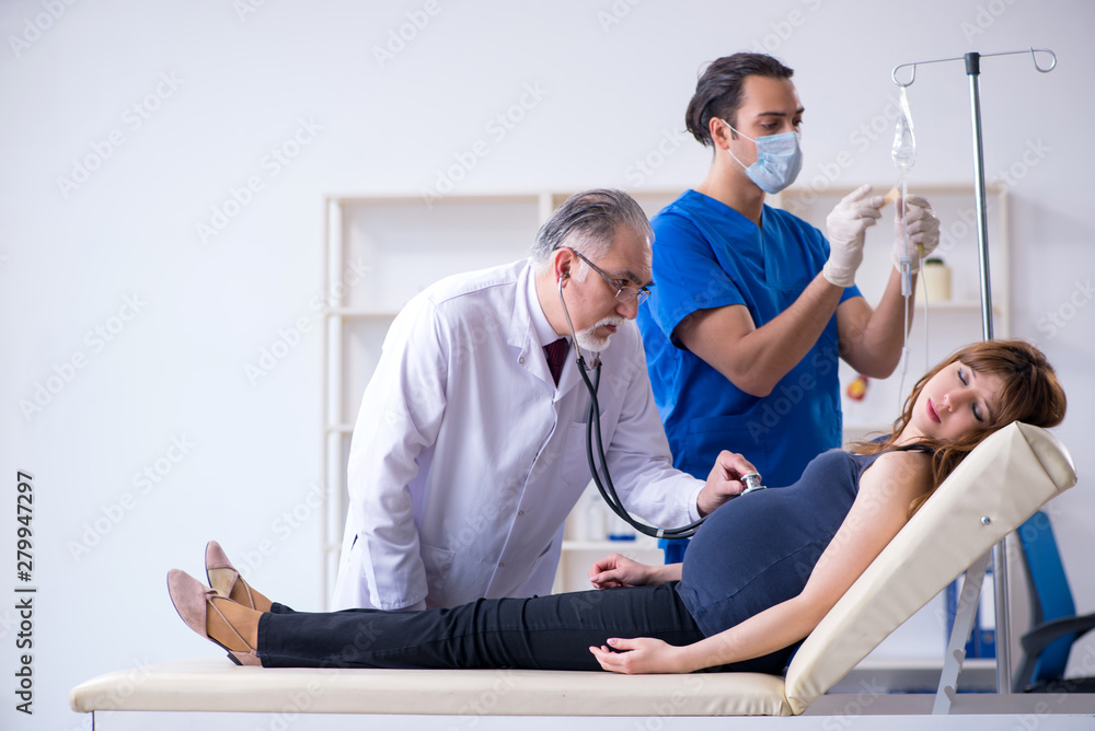 Fototapeta premium Two doctors examining young woman