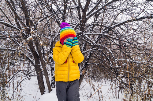 The child dabbles and plays outside in the winter photo