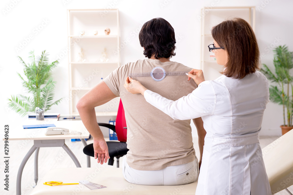 Obraz premium Female doctor checking patient's joint flexibility with goniometer