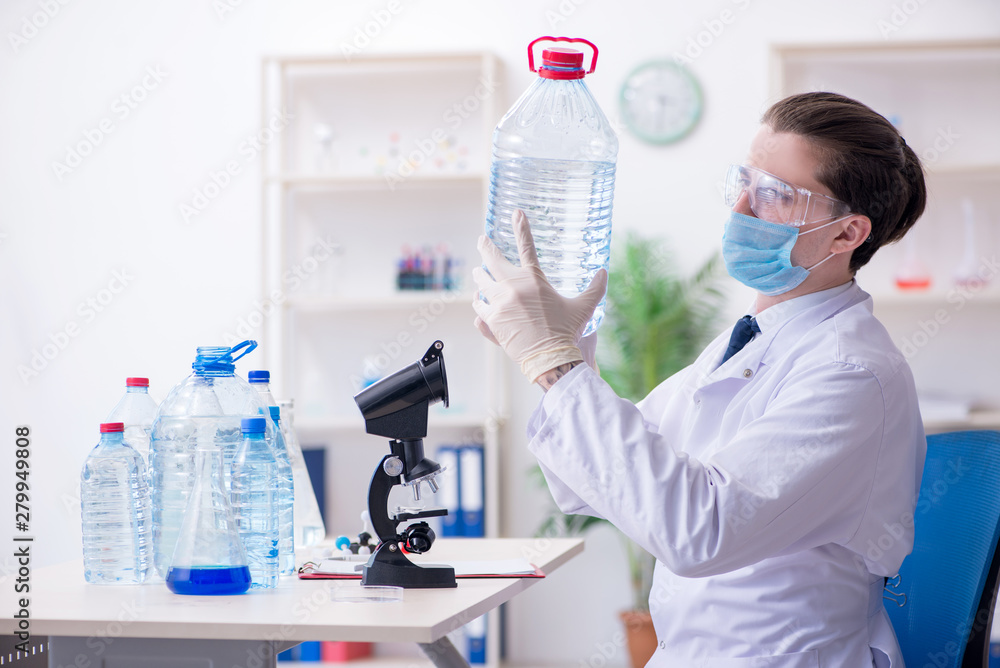Fototapeta premium Young male chemist experimenting in lab
