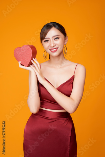 Beautiful woman with heart shaped box on color background. © makistock