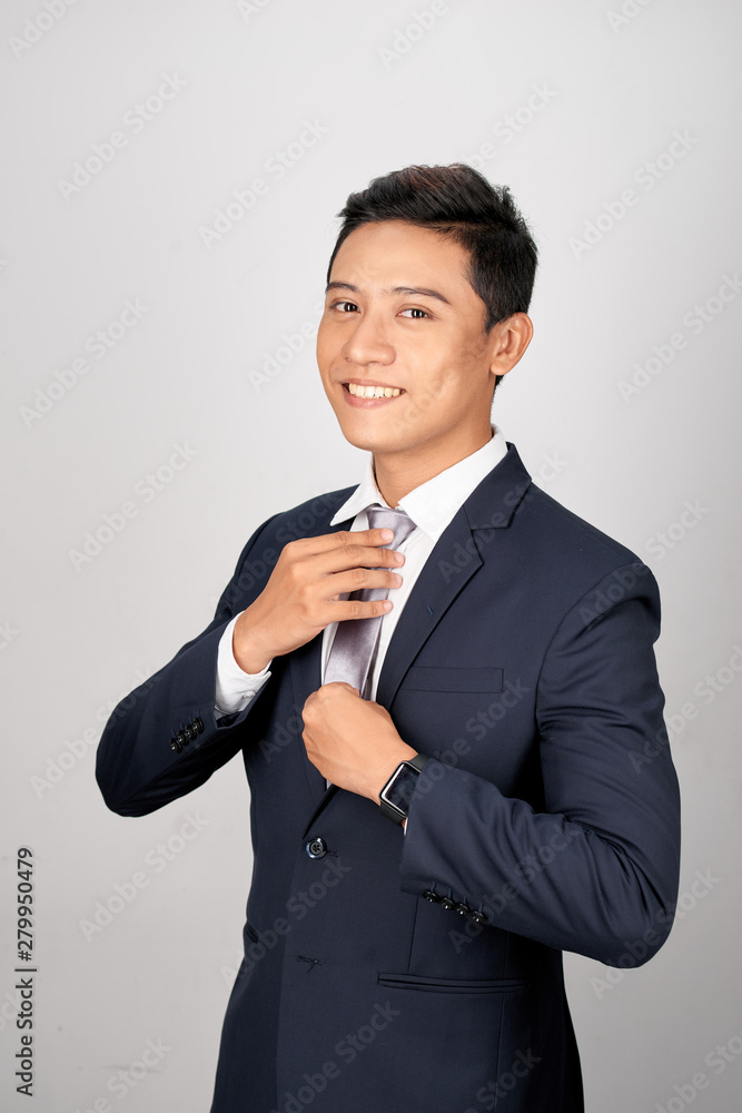 Asian Businessman adjusting gray tie, isolated on white background Asian Businessman adjusting gray tie, isolated on white background