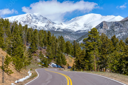 Spring Mountain Road - A Spring view of winding Fall River Road, with snow-capped Ypsilon Mountain and Fairchild Mountain of Mummy Range towering in background, Rocky Mountain National Park, CO, USA.