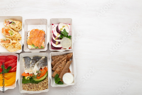Set of healthy meals for the day in lunch boxes stands on a white table with copy space. Concept of menu of proper nutrition is the balance of proteins, fats and carbohydrates
