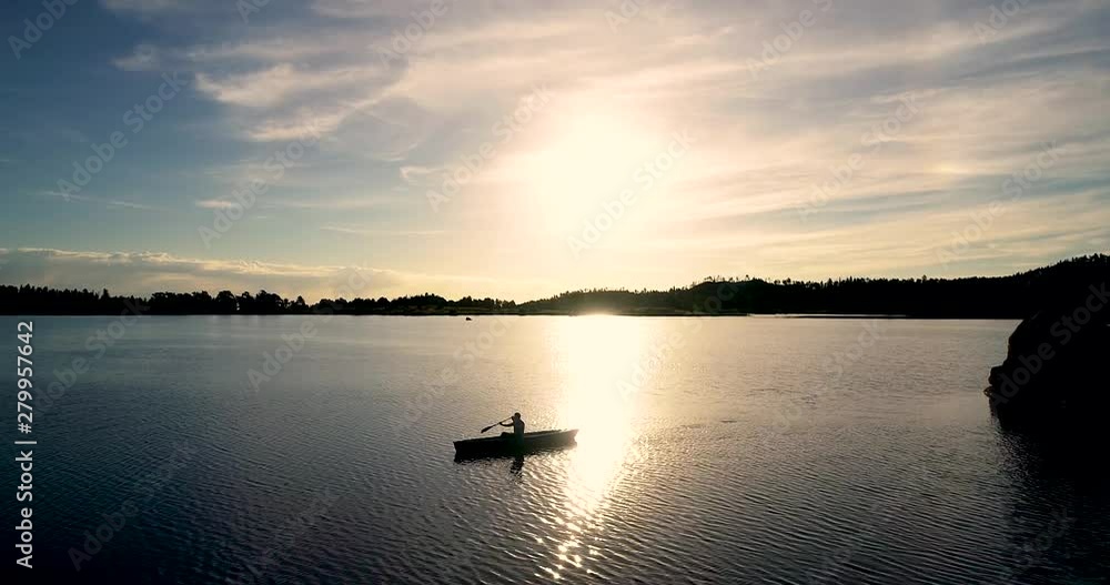 Beautiful Colorado sunrise on a lake with a silhouette of a canoe against the rising sun. Shot take by drone in 4k with 60fps for increased editing options. Beautiful Colorado sunrise on a lake with a silhouette of a canoe against the rising sun. Shot take by drone in 4k with 60fps for increased editing options.