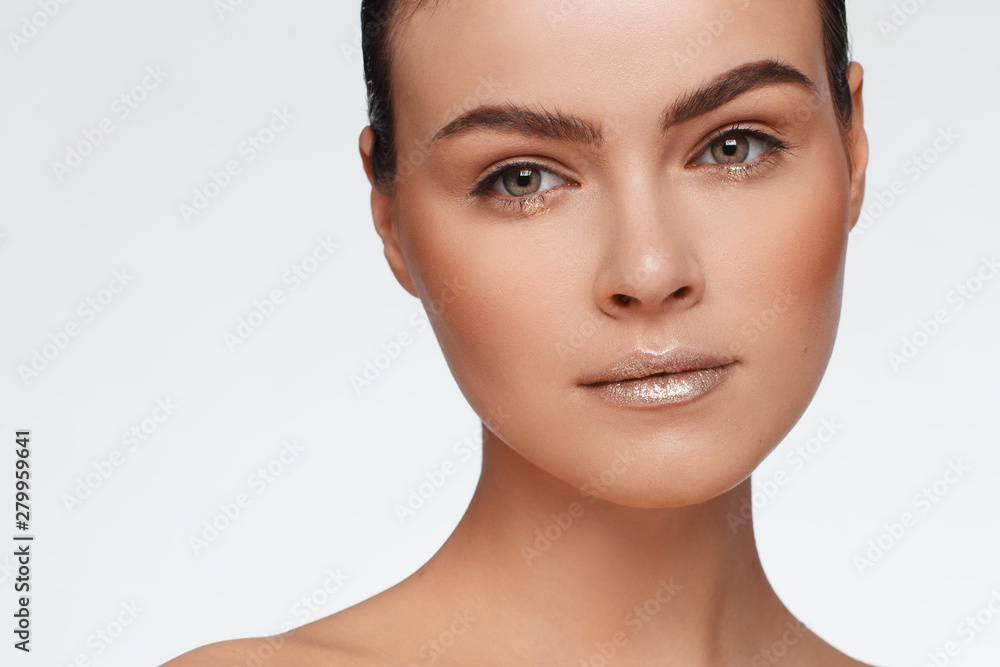 Portrait of a beautiful woman with collected hair and bare shoulders. Studio photo Portrait of a beautiful woman with collected hair and bare shoulders. Studio photo