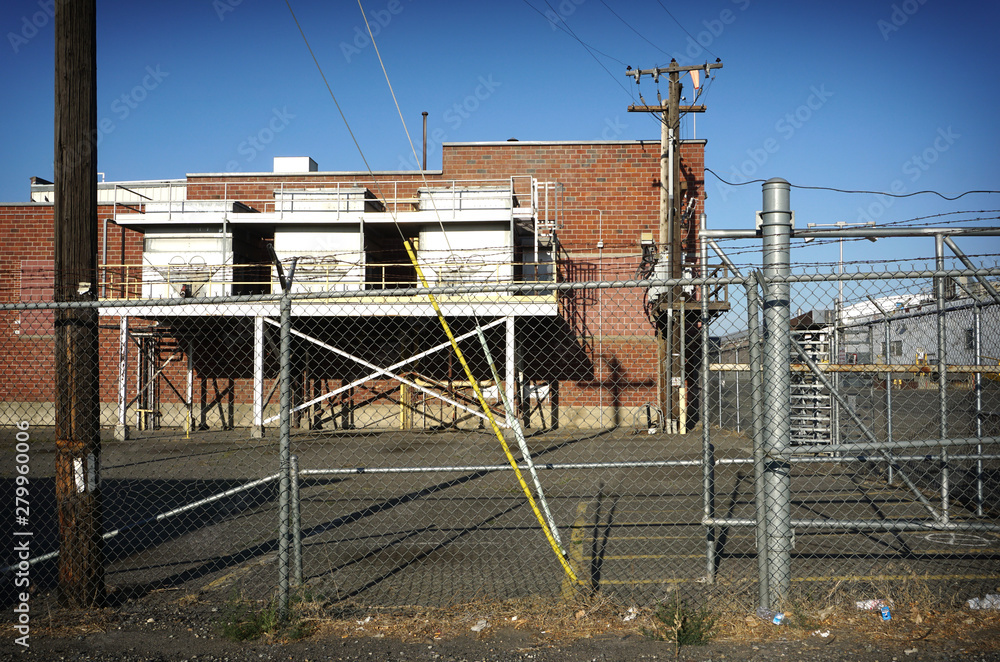 Naklejka premium Industrial building behind fence