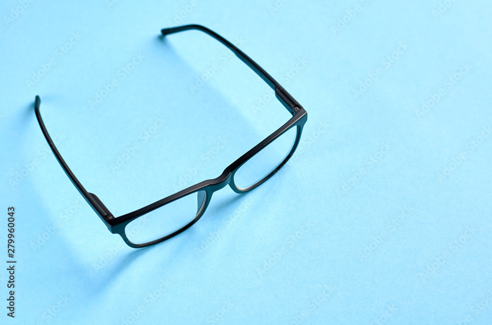 Black glasses on blue background composition, eyeglasses. Black glasses on blue background composition, eyeglasses.