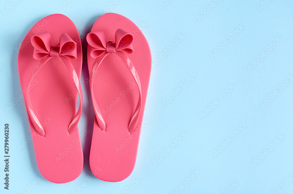 Pink rubber slippers on blue background composition. Pink rubber slippers on blue background composition.