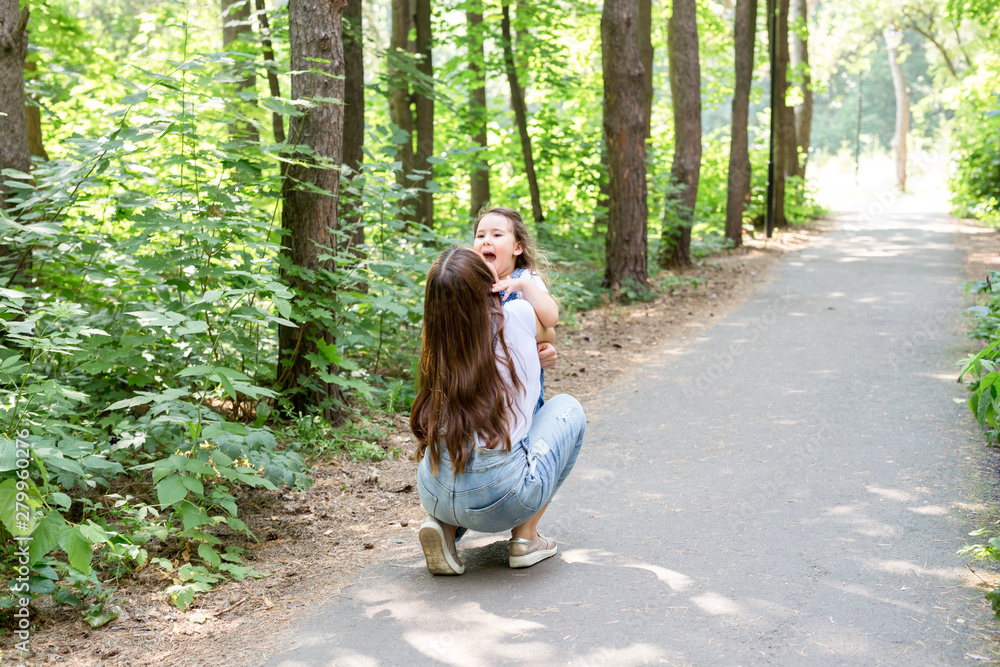 Family and nature concept - Attractive young woman have fun with her little daughter in the park Family and nature concept - Attractive young woman have fun with her little daughter in the park
