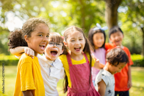 Multi-ethnic group of school children laughing and embracing photo