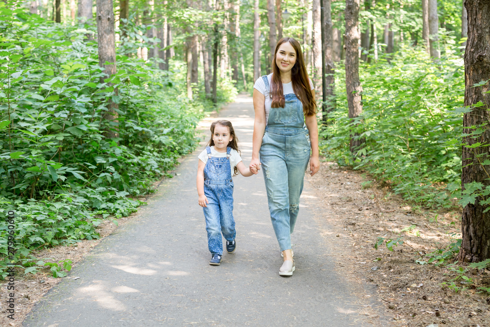 Family, children and nature concept - Portrait of mother with her baby daughter walking in the park Family, children and nature concept - Portrait of mother with her baby daughter walking in the park