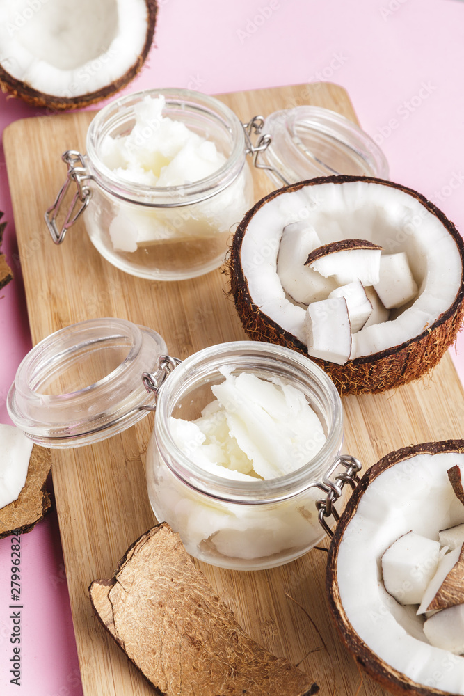 Broken coconut pieces on bright pink background, top view, copy space