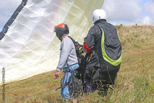 Tandem paraglider launching 