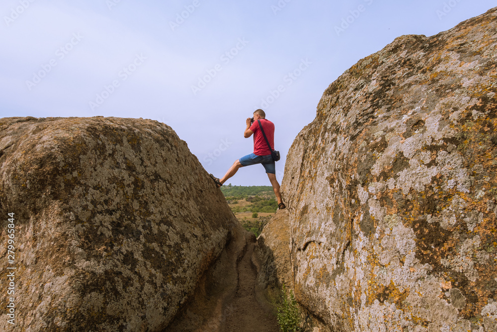 The photographer takes pictures of nature, standing on top of a cliff. The photographer takes pictures of nature, standing on top of a cliff.
