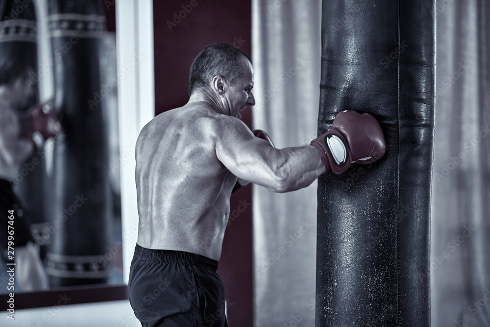 Muay thai fighter working with heavy bag Muay thai fighter working with heavy bag