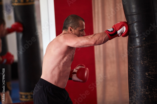 Muay thai fighter working with heavy bag © Xalanx