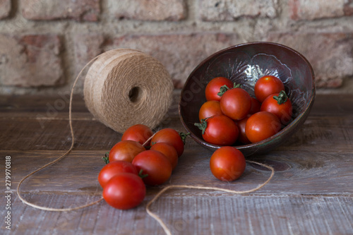 fresh tomatoes in the ceramic plate on the wooden background. photo